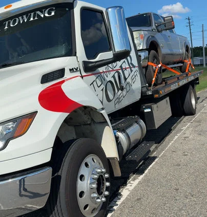 Yoder's flatbed tow truck loading a vehicle